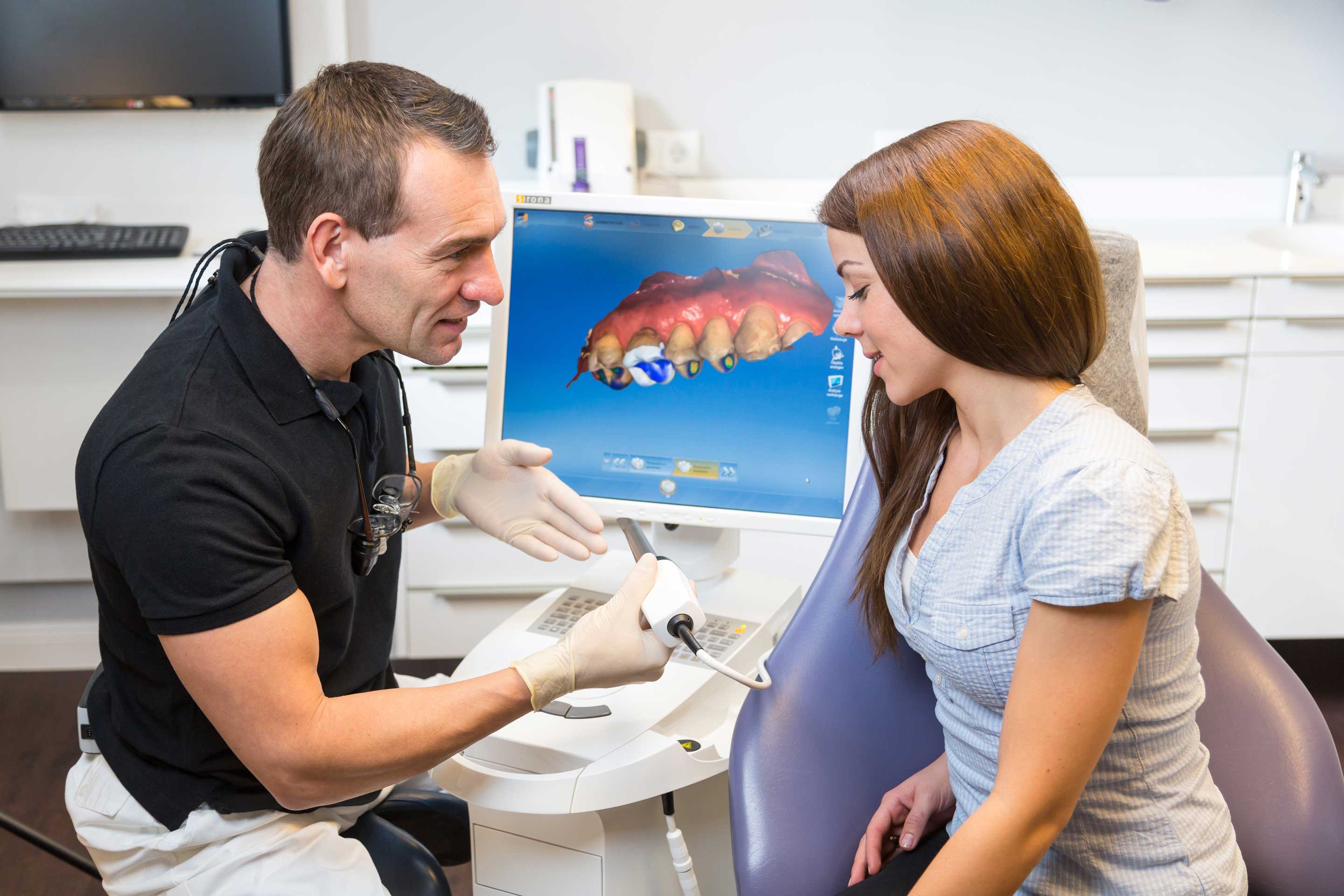 dentist showing female patient CEREC machine and equipment, Portland OR CEREC single-visit crowns